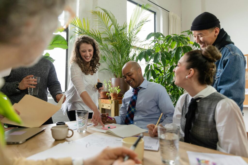 A group of colleagues meet in the office around a table to go over inclusive hiring best practices